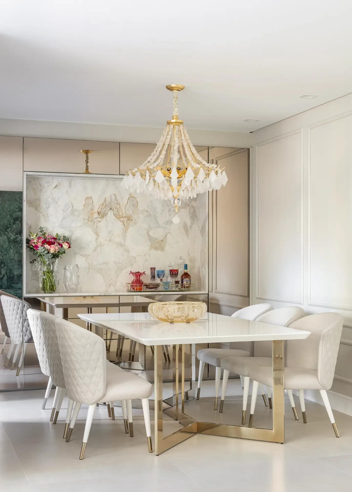 Sala de jantar com mesa, cadeiras estofadas e lustre